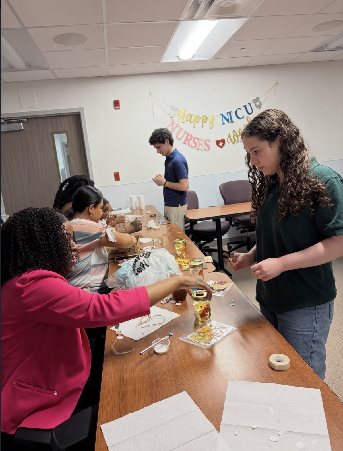 Volunteers helping participants create crafts at a community event